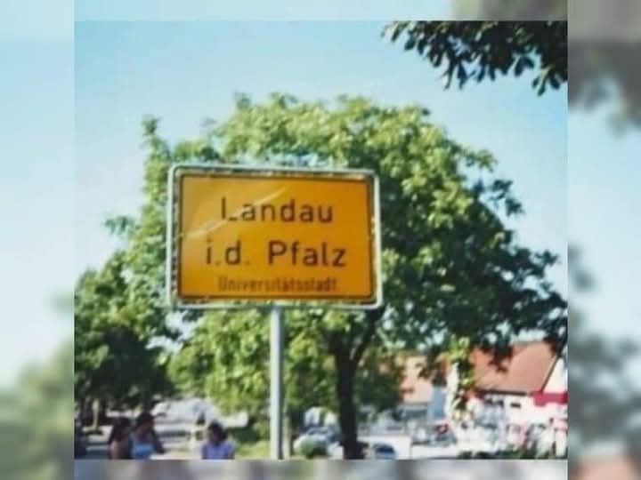 gehäkelter Teddybär, der eine grüne Latzhose trägt