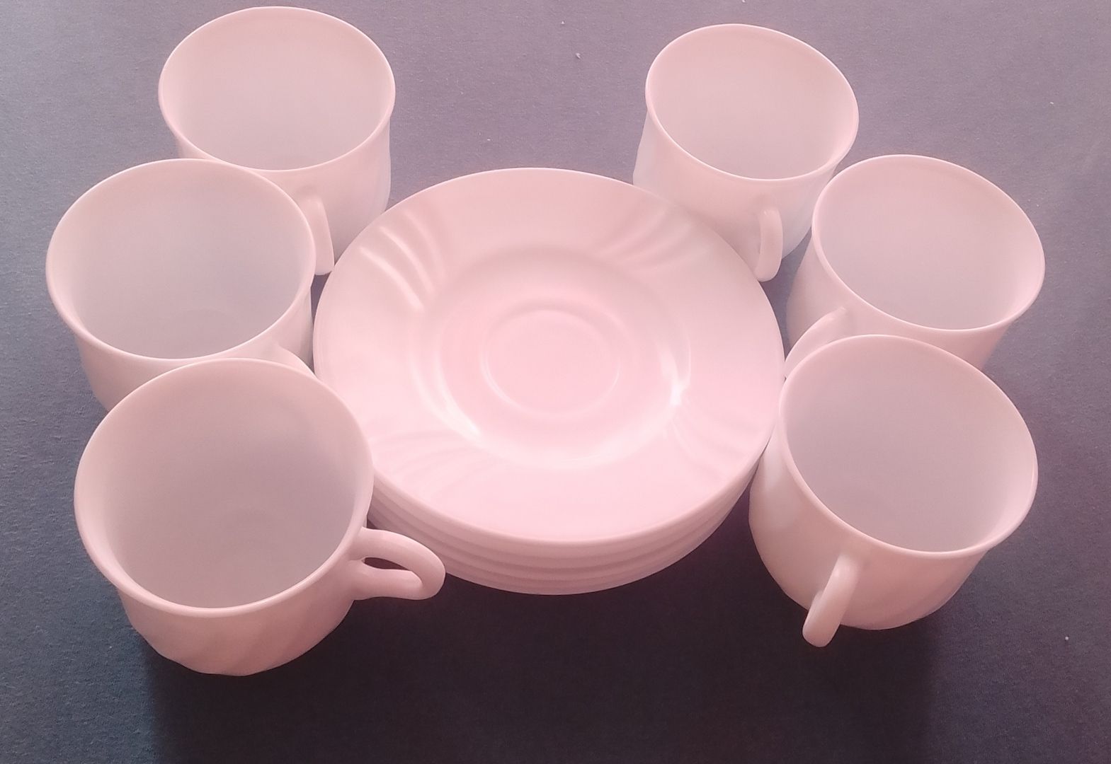 Das Bild zeigt ein Set aus sechs weißen Kaffeetassen oder Teetassen