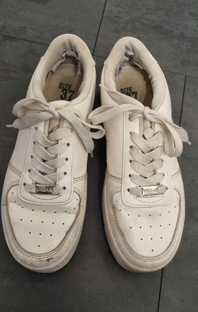 Getragene, abgenutzte weiße Turnschuhe zu verkaufen