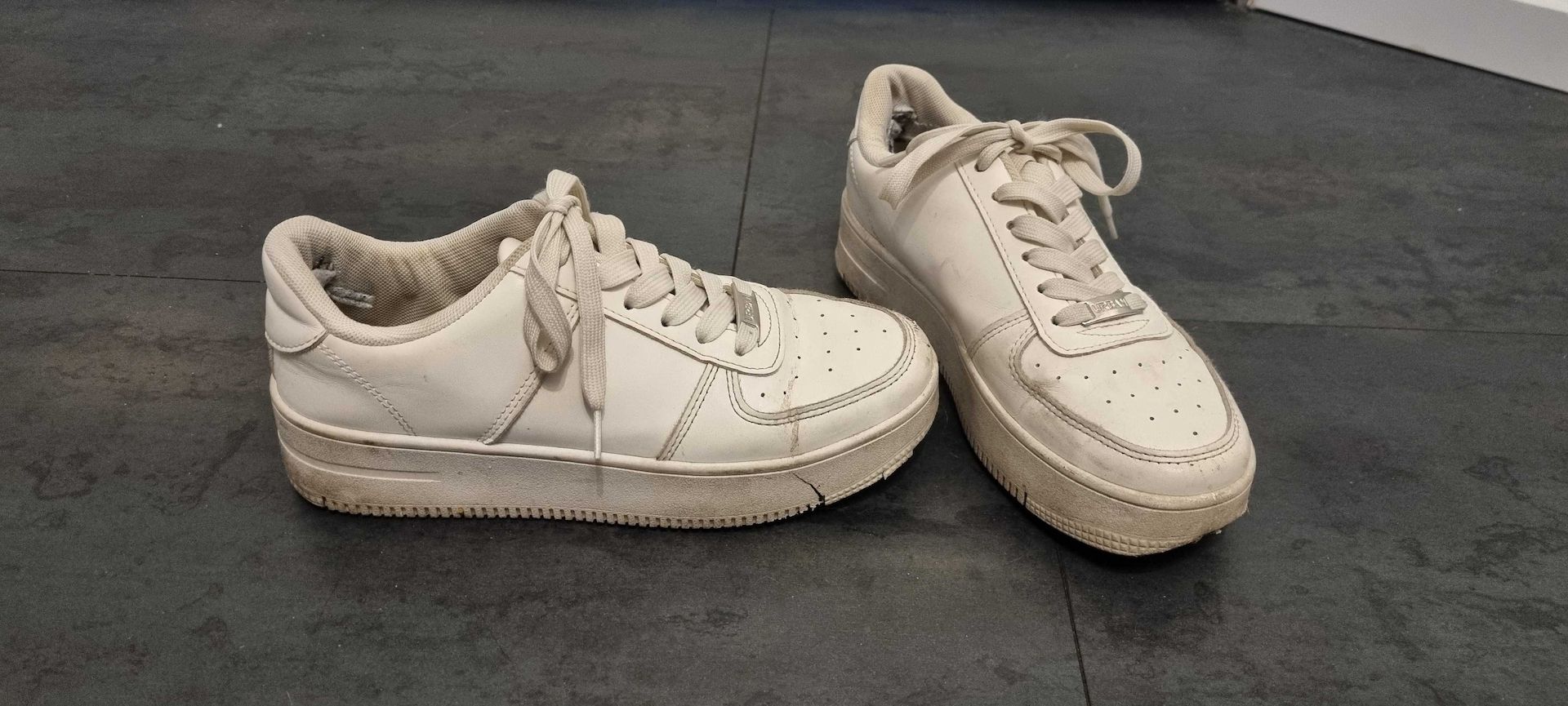 Getragene, abgenutzte weiße Turnschuhe zu verkaufen