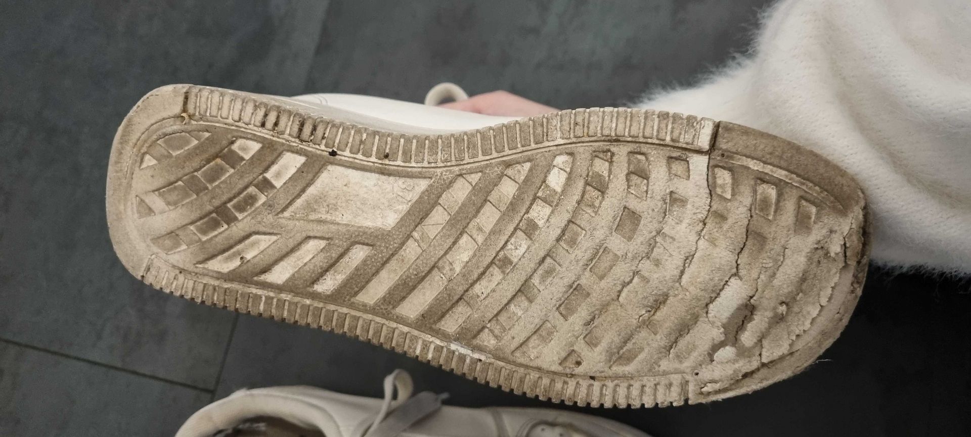 Getragene, abgenutzte weiße Turnschuhe zu verkaufen